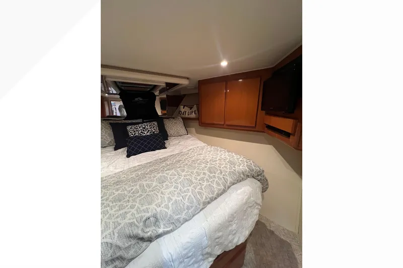 Slide: The Image of Luxurious bedroom interior of 1999 Viking 60 CPMY yacht with cozy bedding and wooden cabinets. - 85