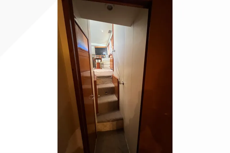Slide: The Image of Interior view of 1999 Viking 60 CPMY yacht, featuring a narrow hallway and stairs. - 95