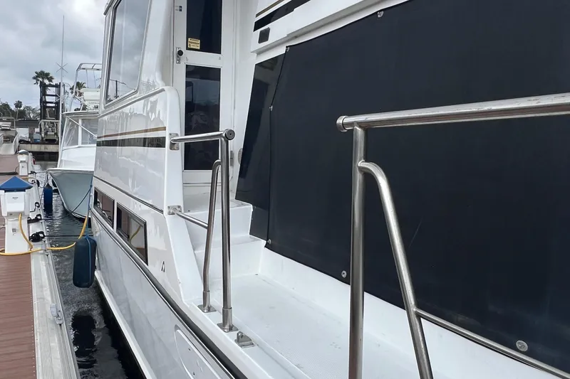 Slide: The Image of 1998 Hyatt 51 Aft Cabin Motor Yacht docked, showcasing sleek design and stainless steel railings. - 20