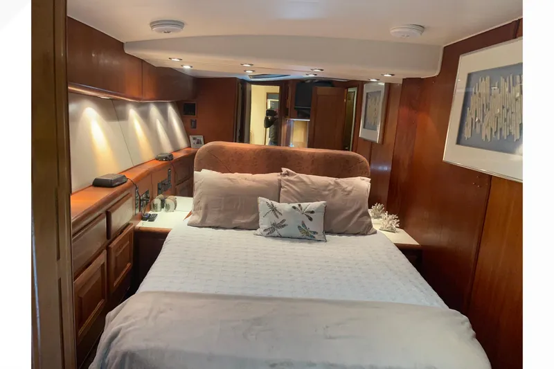 Slide: The Image of Luxurious bedroom interior of a 1991 Viking Convertible yacht with elegant wood paneling. - 61