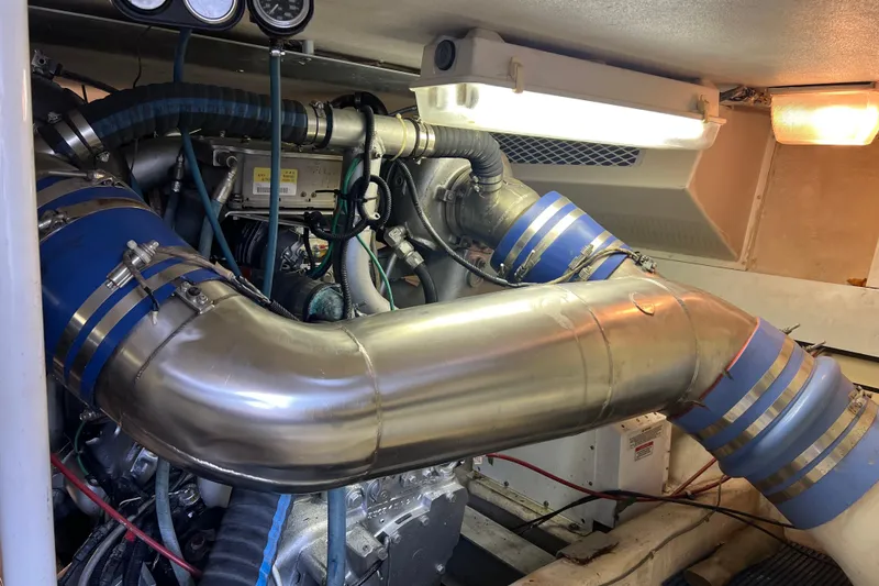 Slide: The Image of Engine room of a 1991 Viking Convertible boat with visible exhaust pipes. - 82