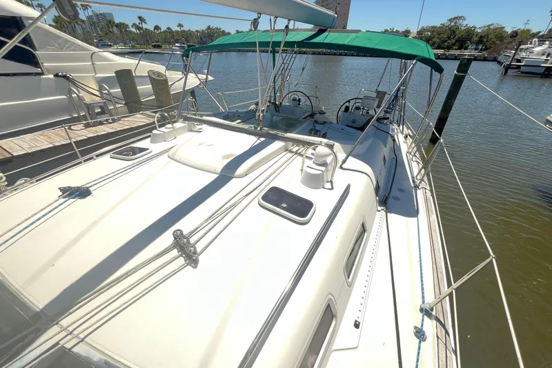 Slide: The Image of Beneteau Oceanis 473 sailboat docked, featuring green canopy and spacious deck, 2001 model. - 26