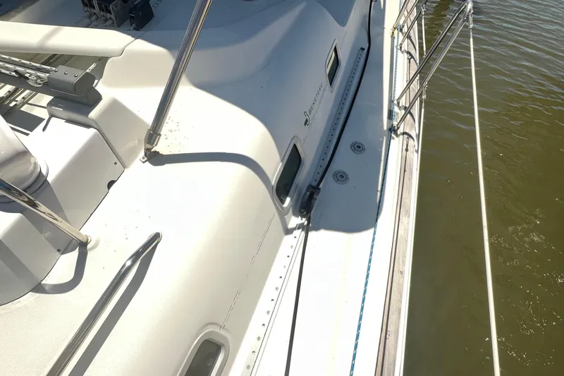 Slide: The Image of Deck view of a 2001 Beneteau Oceanis 473 sailboat, showcasing sleek design and railing. - 27