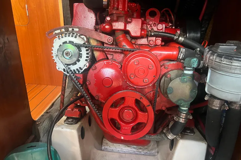 Slide: The Image of Engine of a 2001 Beneteau Oceanis 473 sailboat, showcasing red components and belts. - 112