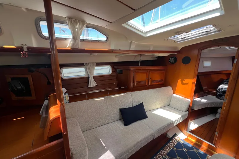 Slide: The Image of Interior of 2001 Beneteau Oceanis 473 sailboat, featuring cozy seating and natural light. - 56