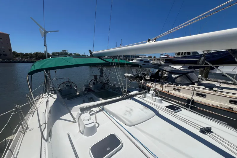 Slide: The Image of Sailboat Beneteau Oceanis 473, 2001 model, docked with green canopy and wind turbine. - 17