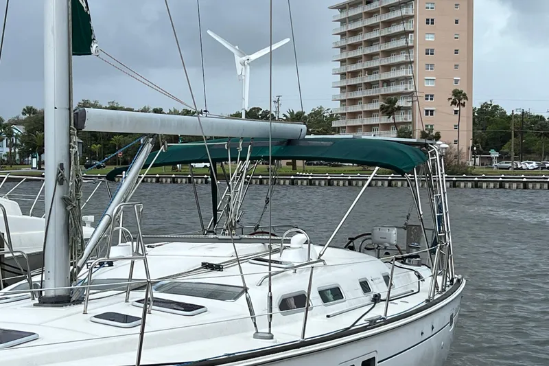 Slide: The Image of Beneteau Oceanis 473 sailboat docked, 2001 model, with green canopy and wind turbine. - 1