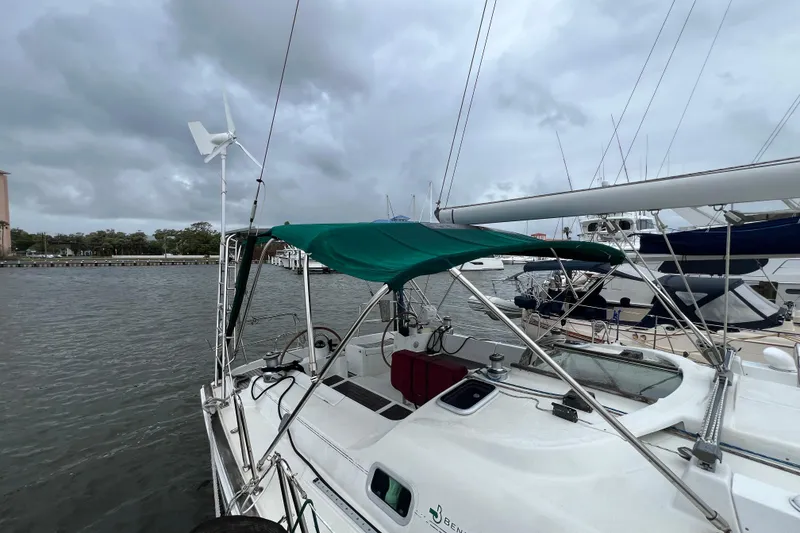Slide: The Image of Beneteau Oceanis 473 sailboat, 2001 model, docked with green canopy and wind turbine. - 11