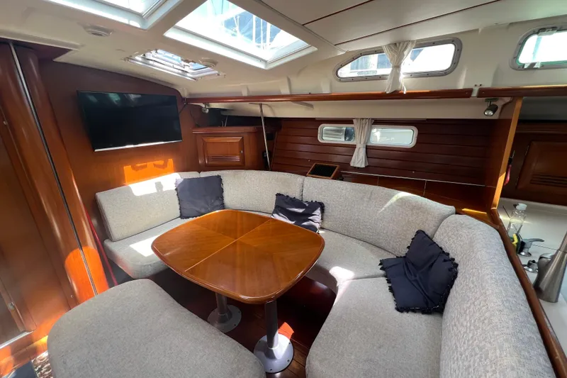 Slide: The Image of Interior of 2001 Beneteau Oceanis 473 yacht with cozy seating and wooden table. - 54