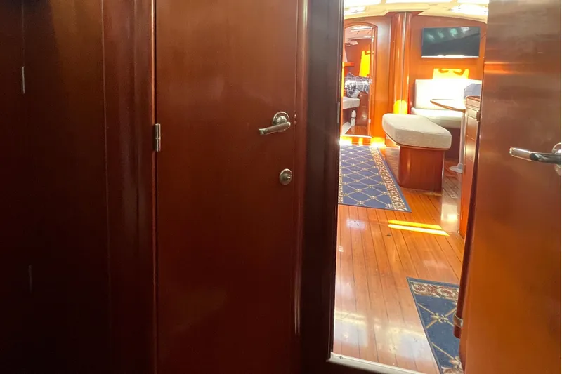 Slide: The Image of Interior view of 2001 Beneteau Oceanis 473 yacht, featuring polished wood doors and cozy cabin. - 84