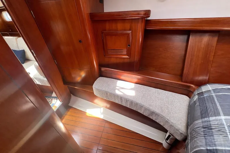 Slide: The Image of Interior of 2001 Beneteau 473 yacht with wooden paneling and cushioned seating. - 92