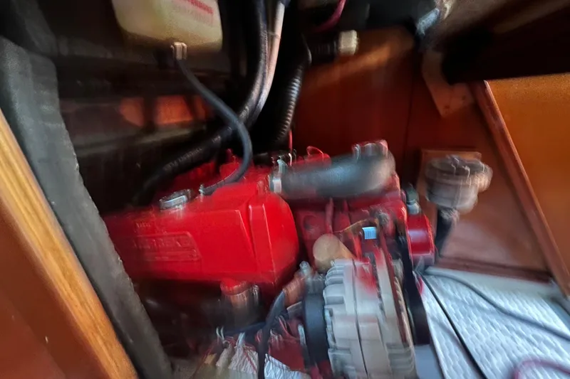 Slide: The Image of Engine compartment of a 2001 Beneteau Oceanis 473 sailboat, featuring a red engine. - 115