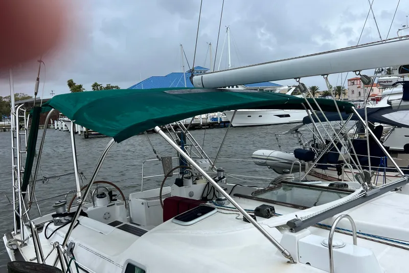 Slide: The Image of Beneteau Oceanis 473 sailboat, 2001 model, docked with green canopy, overcast sky. - 4