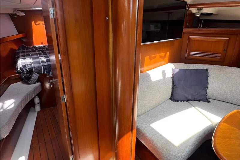 Slide: The Image of Interior of 2001 Beneteau Oceanis 473 yacht, featuring cozy seating and elegant wood finishes. - 59
