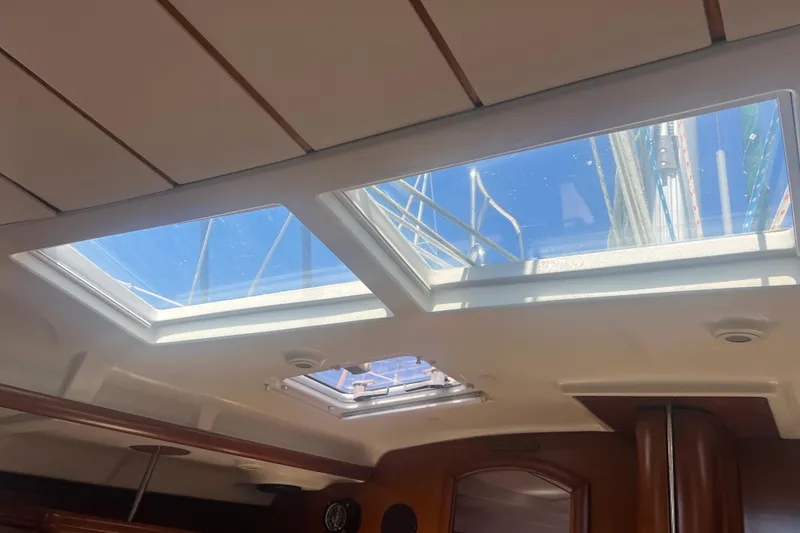 Slide: The Image of Interior view of 2001 Beneteau Oceanis 473 sailboat with skylights and wooden accents. - 62