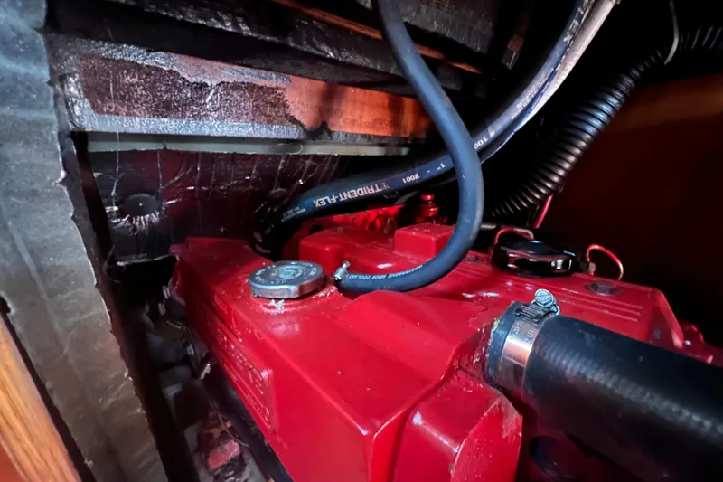 Slide: The Image of Engine compartment of a 2001 Beneteau Oceanis 473 sailboat, featuring red engine components. - 113