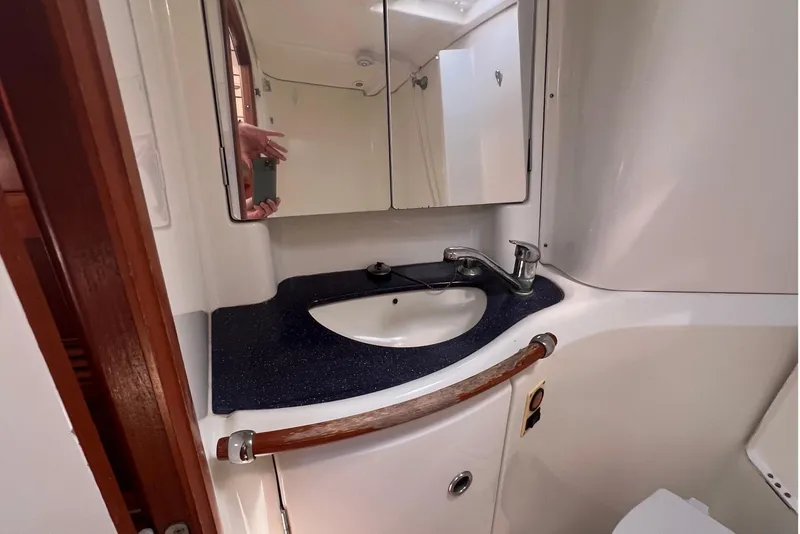 Slide: The Image of Bathroom interior of 2001 Beneteau Oceanis 473 yacht, featuring sink, mirror, and toilet. - 95