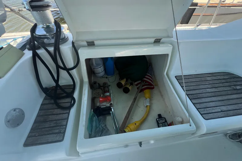 Slide: The Image of Open storage compartment on a 2001 Beneteau Oceanis 473 sailboat, containing various boating supplies. - 33