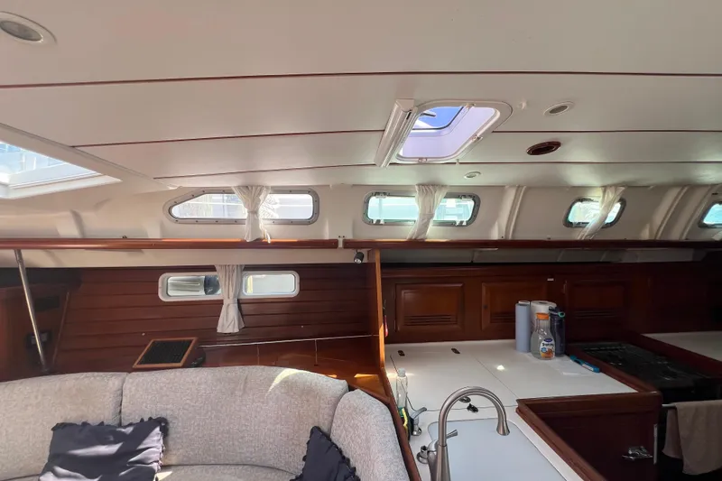 Slide: The Image of Interior of 2001 Beneteau Oceanis 473 yacht, featuring elegant wood paneling and modern amenities. - 57