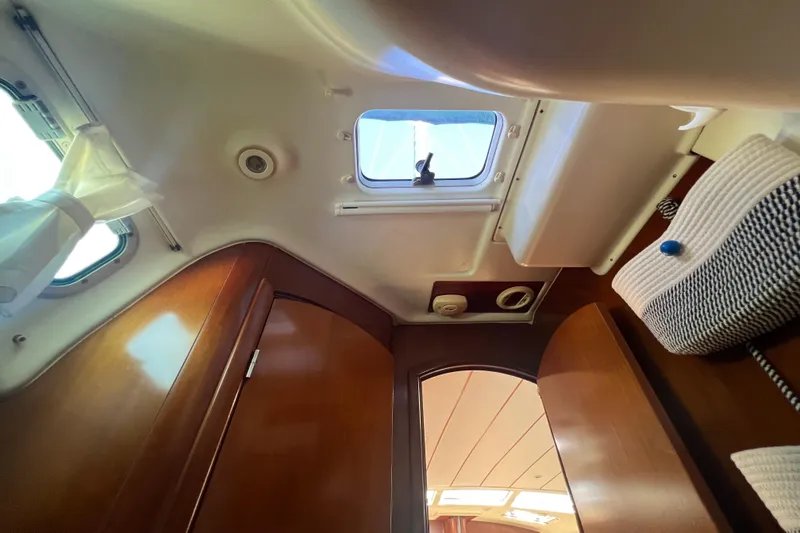 Slide: The Image of Interior view of 2001 Beneteau Oceanis 473 sailboat cabin with wooden finish and ceiling hatch. - 86