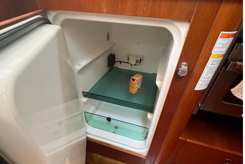 Slide: The Image of Open refrigerator inside 2001 Beneteau Oceanis 473 yacht, showcasing wooden interior and flooring. - 75