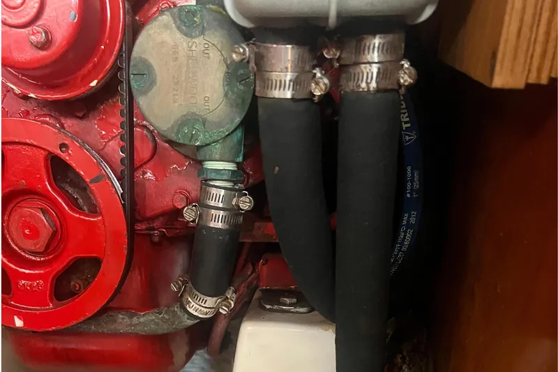 Slide: The Image of Engine compartment of a 2001 Beneteau Oceanis 473 sailboat, showing hoses and mechanical components. - 103