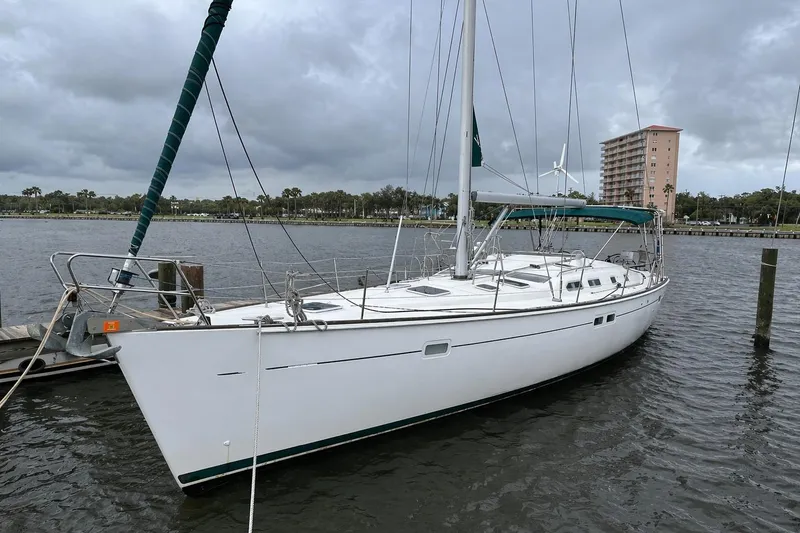 The Image of 2001 Beneteau 473 sailboat docked on a cloudy day, showcasing sleek design and spacious deck. - 0