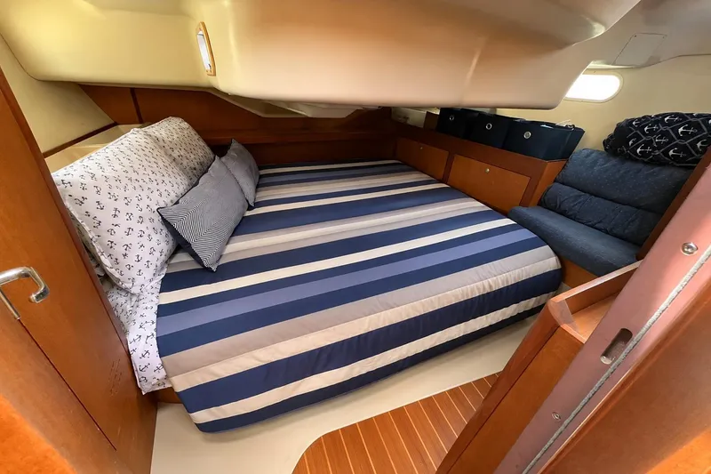Slide: The Image of Cozy cabin interior of a 1999 Hunter 380 sailboat with striped bedding. - 66