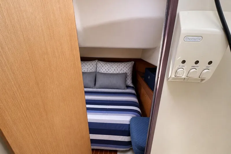 Slide: The Image of Cozy cabin interior of 1999 Hunter 380 yacht with striped bedding and dispenser. - 68