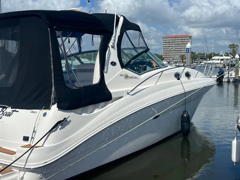 Slide: The Image of 2003 Sea Ray 320 Sundancer boat docked at marina under cloudy sky. - 1