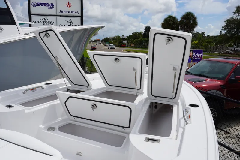 Slide: The Image of 2027 Sportsman Masters 247 Bay Boat with open storage compartments, displayed outdoors. - 14