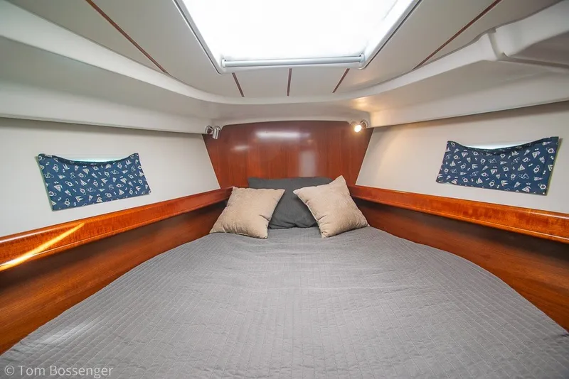 Slide: The Image of Interior cabin of 2005 Beneteau Oceanis 423 yacht, featuring a cozy bed and wooden accents. - 28