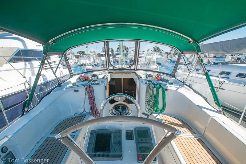 Slide: The Image of Cockpit view of 2005 Beneteau Oceanis 423 sailboat with green canopy and marina background. - 7
