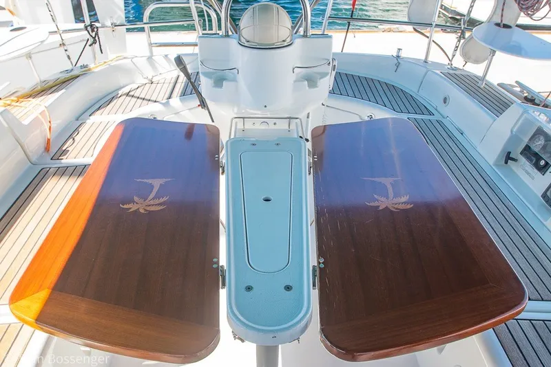 Slide: The Image of Cockpit of 2005 Beneteau Oceanis 423 sailboat with wooden folding tables and steering wheel. - 42