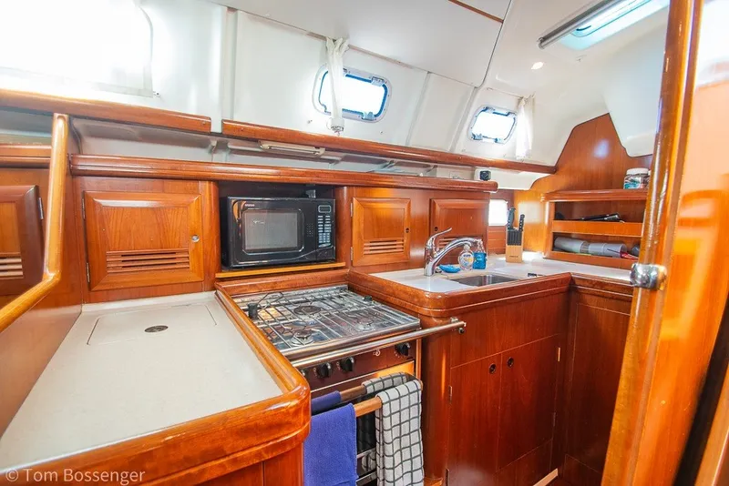 Slide: The Image of Interior view of 2005 Beneteau Oceanis 423 yacht kitchen with wood cabinetry and appliances. - 15