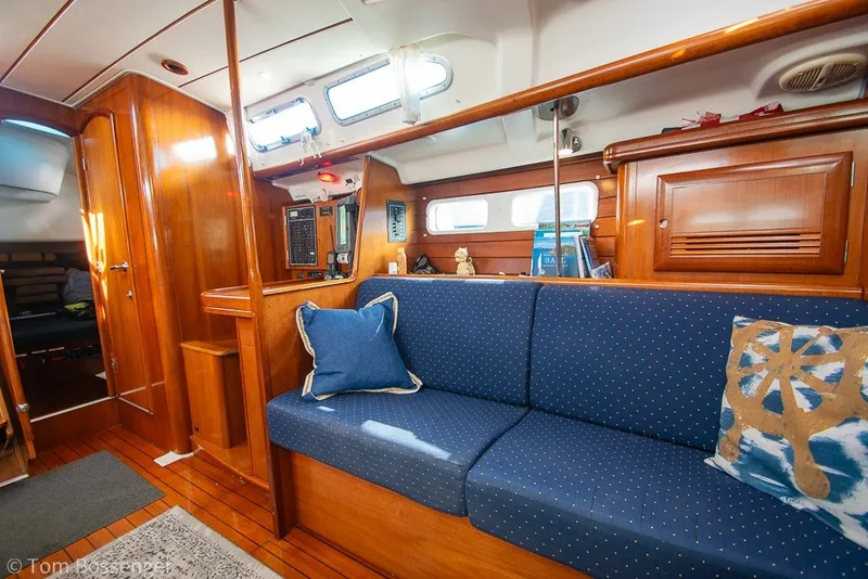 Slide: The Image of Interior of 2005 Beneteau Oceanis 423 yacht with blue cushioned seating and wooden cabinetry. - 22