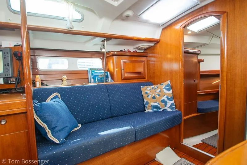 Slide: The Image of Interior of 2005 Beneteau Oceanis 423 sailboat with blue cushioned seating and wooden cabinetry. - 20
