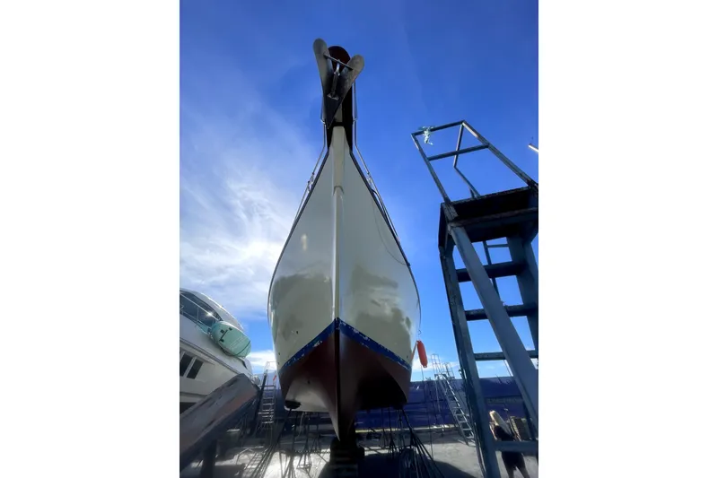 Slide: The Image of 1978 Thompson motor yacht on dry dock under clear blue sky. - 34