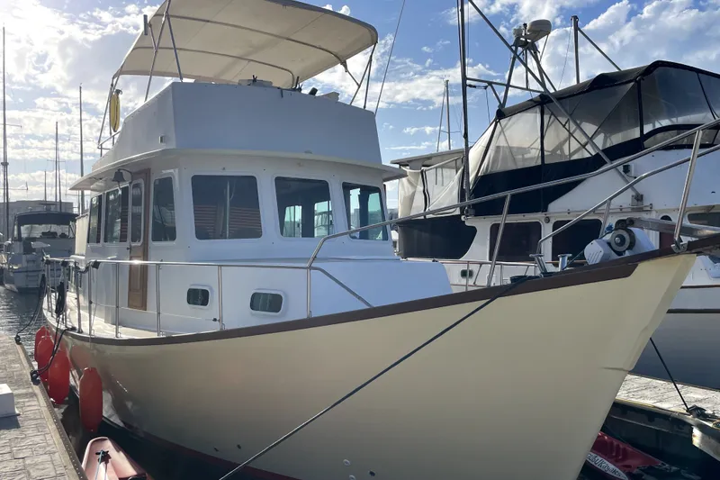 Slide: The Image of 1978 Thompson motor yacht docked at marina under clear blue sky. - 2