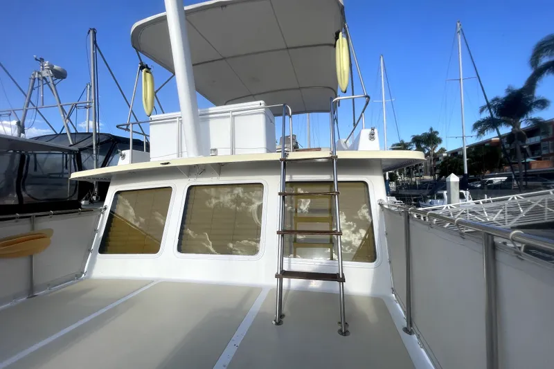 Slide: The Image of 1978 Thompson motor yacht with upper deck ladder and canopy, docked at marina. - 8
