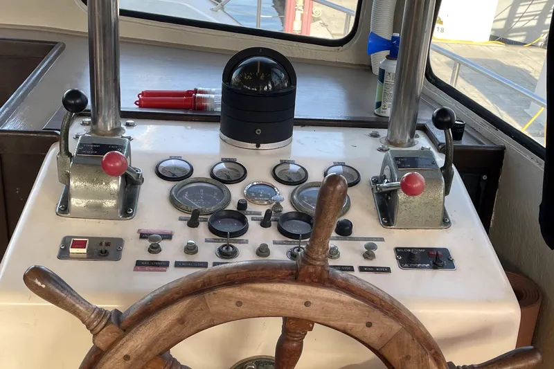 Slide: The Image of 1978 Thompson motor yacht helm with wooden wheel and navigational instruments. - 28