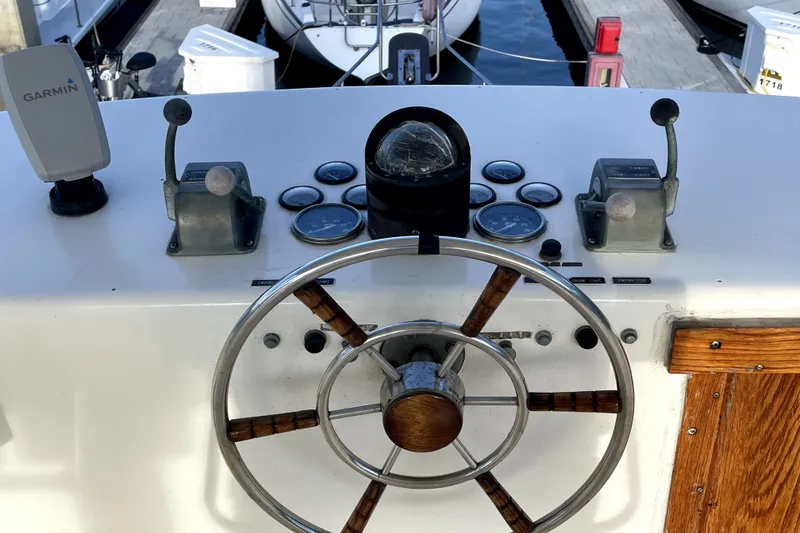 Slide: The Image of 1978 Thompson motor yacht helm with wooden steering wheel and navigation instruments. - 6