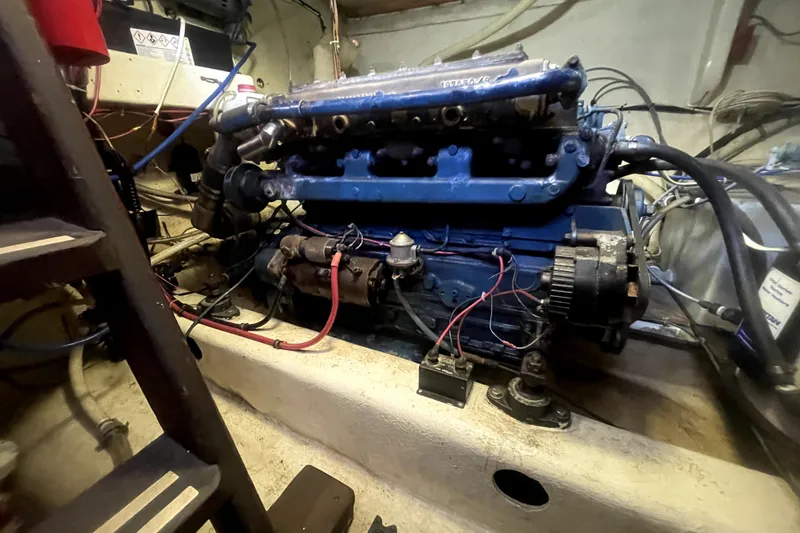 Slide: The Image of Engine room of a 1978 Thompson motor yacht, featuring a blue engine and wiring. - 30