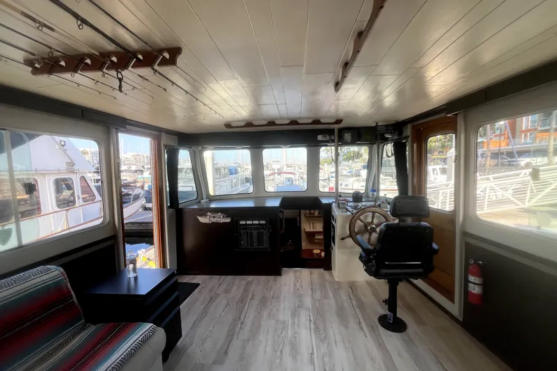 Slide: The Image of Interior of a 1978 Thompson motor yacht with helm, seating, and marina view. - 17