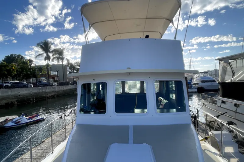 Slide: The Image of 1978 Thompson motor yacht docked at marina under a partly cloudy sky. - 22