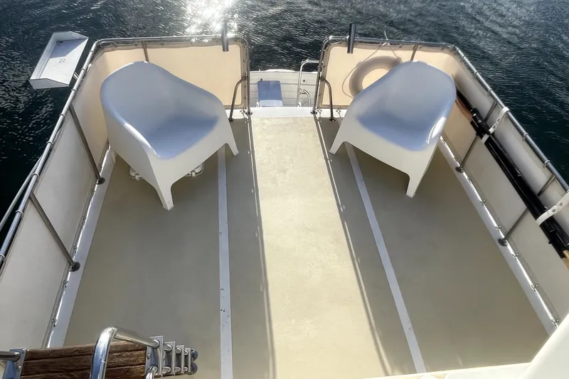 Slide: The Image of Two white chairs on the deck of a 1978 Thompson motor yacht. - 5