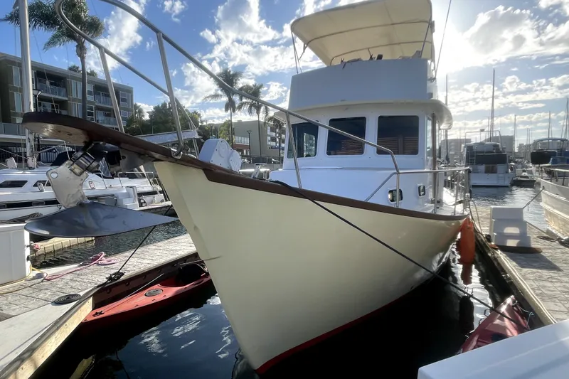 The Image of 1978 Thompson motor yacht docked at marina under a partly cloudy sky. - 0