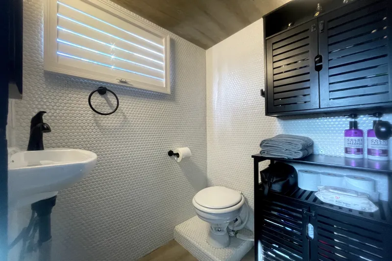 Slide: The Image of Bathroom interior of a 1978 Thompson motor yacht with modern fixtures and storage. - 11