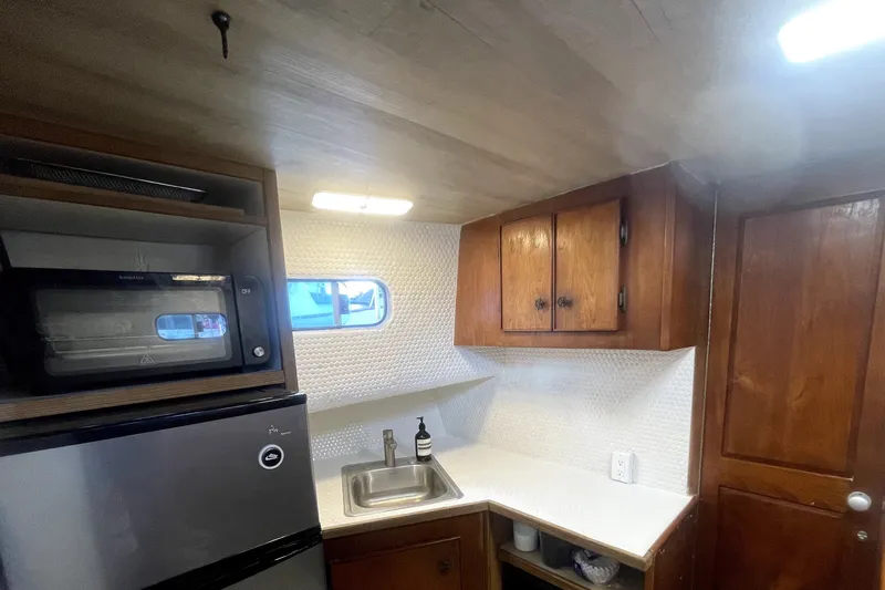Slide: The Image of 1978 Thompson motor yacht kitchen with wooden cabinets, sink, and compact appliances. - 14