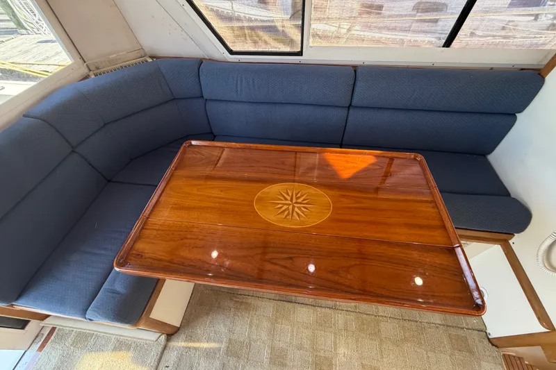 Slide: The Image of Interior of 2000 Albin 35 Tournament Express with wooden table and blue cushioned seating. - 39